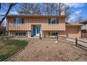 Charming two-story home with a blue front door, landscaped front yard, and a two car garage at 1529 Ashcroft Dr, Longmont, CO 80501