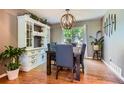 Elegant dining room with wood floors, a statement light fixture, and a vintage storage cabinet at 9492 Crestmore Way, Highlands Ranch, CO 80126