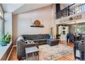 Spacious living room with high ceilings, a cozy gray sectional, and an open view to the dining area at 9492 Crestmore Way, Highlands Ranch, CO 80126