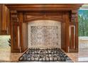 Kitchen detail shows cooktop with custom backsplash and range hood at 10518 Christopher Dr, Conifer, CO 80433