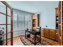 Bright office space includes a built-in bookcase, desk, and a decorative rug at 6642 S Routt St, Littleton, CO 80127