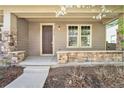 Welcoming front porch with stone accents, a cozy seating area, and the house number prominently displayed at 3332 Valentia St, Denver, CO 80238