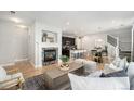 Open-concept living room showcasing a fireplace, hardwood floors, and seamless flow to the kitchen at 3332 Valentia St, Denver, CO 80238