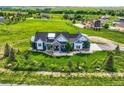 Aerial shot of a beautiful blue home on a vast green lot in a gorgeous rural neighborhood at 41975 Muirfield Loop, Elizabeth, CO 80107