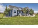Charming two-story home featuring a well-manicured lawn and beautiful landscaping at 41975 Muirfield Loop, Elizabeth, CO 80107