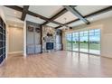 Spacious living room with hardwood floors, stone fireplace, and beamed ceiling at 41975 Muirfield Loop, Elizabeth, CO 80107