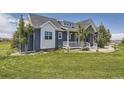 Beautiful home with a manicured lawn, a charming porch and lovely blue and white exterior paint at 41975 Muirfield Loop, Elizabeth, CO 80107