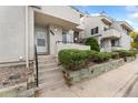 Front view of condo building with landscaping and steps leading to entrance at 1830 Newland Ct # 106, Lakewood, CO 80214