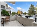 Spacious patio with seating area overlooking a parking lot and trees at 1830 Newland Ct # 106, Lakewood, CO 80214