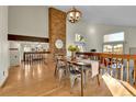 Charming dining room featuring a brick fireplace, wood floors and modern decor with view to a cozy living area at 7877 S Ulster St, Centennial, CO 80112