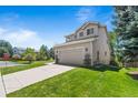 A lovely two-story home boasts an attached garage and beautifully maintained lawn at 21690 Longs Peak Ln, Parker, CO 80138
