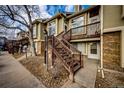 Townhome exterior with wooden stairs and landscaping at 1885 S Quebec Way # 16, Denver, CO 80231