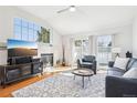 Bright living room with large windows, fireplace, hardwood floors and comfortable seating at 12638 James Pt, Broomfield, CO 80020