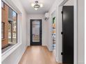 Inviting entryway with modern black door, light wood floors, and large window at 3275 Lawrence St, Denver, CO 80205