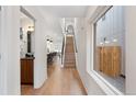 Hallway features hardwood floors, staircase with modern railing, natural light, and neutral walls at 3275 Lawrence St, Denver, CO 80205