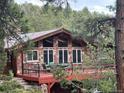 Beautiful stone facade home featuring a spacious deck and lots of windows at 21191 Pleasant Park Rd, Conifer, CO 80433