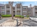 Condo exterior featuring stone accents, balconies, and manicured landscaping at 9222 E Arbor Cir # L, Englewood, CO 80111