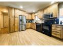 Well-maintained kitchen featuring stainless steel appliances, wooden cabinets, and laminate floors at 5690 W 79Th Ave, Arvada, CO 80003