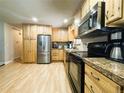 Well-maintained kitchen featuring stainless steel appliances, wooden cabinets, and laminate floors at 5690 W 79Th Ave, Arvada, CO 80003
