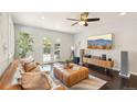 Cozy living room with a brown leather couch, a modern TV and doors leading to the outside area at 2408 Irving St, Denver, CO 80211