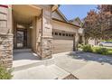 Inviting home featuring an attached two car garage, covered porch, and attractive stone accents on columns at 25561 E 5Th Pl, Aurora, CO 80018