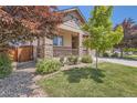 Charming home featuring a cozy porch, manicured landscaping and the stone veneer accents on the columns at 25561 E 5Th Pl, Aurora, CO 80018