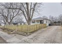 White Ranch home with wood fence and driveway at 1840 Rowena St, Thornton, CO 80229