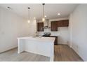 Bright kitchen features a large island, modern appliances, stylish cabinets, and contemporary pendant lighting at 26789 E Cedar Ave, Aurora, CO 80018