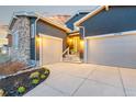 Home exterior showing the driveway leading to two garages and a manicured flower bed at 17720 W 94Th Dr, Arvada, CO 80007