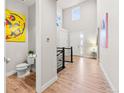 Hallway with wood floors, a small lavatory, and modern artwork at 17720 W 94Th Dr, Arvada, CO 80007