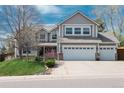 Charming two-story home with a three-car garage, well-maintained lawn, and inviting curb appeal at 9325 Lark Sparrow Dr, Highlands Ranch, CO 80126