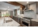 Modern kitchen features stainless steel appliances, stone countertops, and a herringbone tile backsplash at 9325 Lark Sparrow Dr, Highlands Ranch, CO 80126