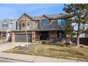 Charming two-story home featuring a brick and siding exterior, attached garage, and nicely landscaped front yard at 1711 Spring Water Ln, Highlands Ranch, CO 80129