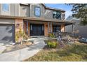 Inviting front entry with double doors, brick accents, landscaping, and a cozy covered porch at 1711 Spring Water Ln, Highlands Ranch, CO 80129