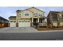 Two-story house with beige siding, stone accents, and a three-car garage at 2521 E 163Rd Pl, Thornton, CO 80602
