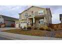 Two-story house with beige siding, stone accents, and a three-car garage at 2521 E 163Rd Pl, Thornton, CO 80602