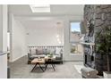 Bright living room featuring skylights and a stone fireplace at 1159 S Otis Pl, Lakewood, CO 80232