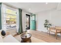 Inviting living room featuring a light-filled window, stylish decor, and a charming turquoise door at 120 W Bayaud Ave, Denver, CO 80223