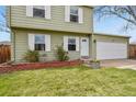 The front yard of this charming home features well-manicured lawn, beautiful shrubbery, and a two car garage at 10645 Moore Ct, Broomfield, CO 80020