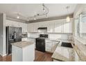 Updated kitchen with white cabinets, granite countertops, and black appliances at 6307 Monterey Pl, Highlands Ranch, CO 80130