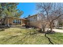 Inviting home exterior featuring a well-manicured lawn, mature tree, and welcoming front entrance at 7586 S Detroit St, Centennial, CO 80122