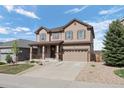 Inviting two-story home with neutral siding, a spacious driveway, and a newly planted tree at 7315 Blue Water Dr, Castle Rock, CO 80108