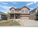 Charming two-story home featuring a covered porch, manicured lawn, and an attached two-car garage at 7315 Blue Water Dr, Castle Rock, CO 80108
