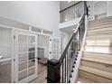 Elegant foyer with high ceilings, wood stairs, and a glass-enclosed office space at 7315 Blue Water Dr, Castle Rock, CO 80108