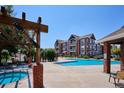 Community pool and hot tub area with a pergola and lounge chairs at 14465 E 1St Dr # C7, Aurora, CO 80011