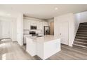 A modern kitchen with an island, stainless steel appliances, and hardwood floors at 577 Nightsky St, Erie, CO 80516