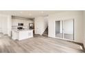 Open-concept living area flows into kitchen with hardwood floors and a sliding glass door at 577 Nightsky St, Erie, CO 80516