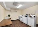 Well-lit laundry room with multiple washers and dryers at 7645 E Quincy Ave # 105, Denver, CO 80237