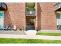 Apartment entrance featuring a well-maintained staircase, small patio, and brick exterior at 3613 S Sheridan Blvd # 10, Denver, CO 80235