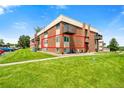 Brick apartment building with well-maintained lawn, lush greenery and a balcony at 3613 S Sheridan Blvd # 10, Denver, CO 80235